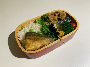 Siyah zemin üzerinde pirinç ve sebzeli taze ton balığı.