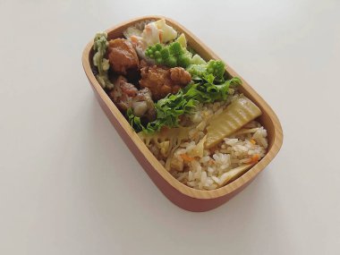 Beyaz arka planda kutuda sebzeli Japon pirinci.