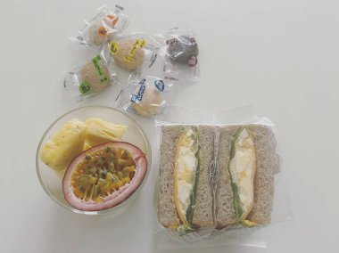 Sağlıklı kahvaltı. Beyaz arka planda peynirli, yumurtalı, meyveli ve tahıllı sandviçler