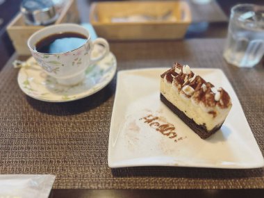 Masada kremalı ve kahve fincanlı lezzetli çikolatalı pasta.