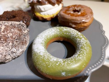 Tabakta şeker tozu olan lezzetli çöreklerden yakın plan bir fotoğraf.