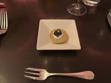 Beyaz bir plaka ve masanın çatalının dikey yakın çekimi.