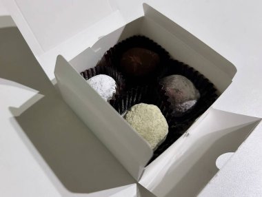 Kutunun üzerinde çikolatalı şekerler var.