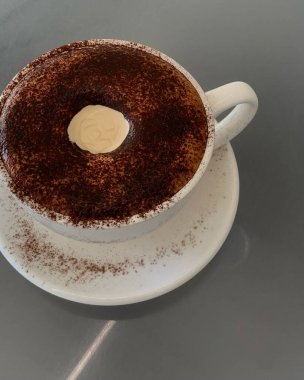 Masanın üzerinde kahve olan bir fincan.