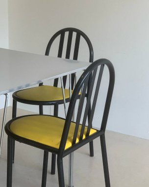 Duvara yakın sandalyeli bir masa.