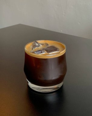 Tahta bir masada bir bardak kahve ve süt.