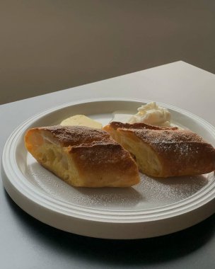 Masadaki beyaz tabakta taze kruvasanlar.