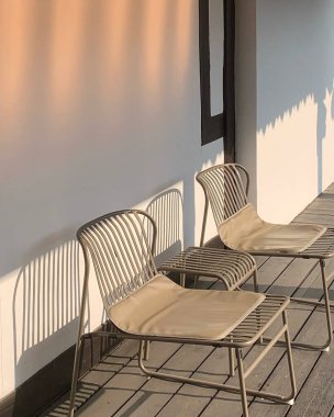 Güneşli bir günde arka arkaya boş beyaz sandalyeler