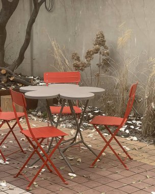 Bahçedeki kırmızı ve beyaz masalar ve sandalyeler