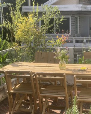 Sandalyeleri ve bitkileri olan ahşap masa.