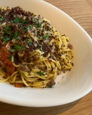 Somon soslu spagetti makarna, domates, peynir, soğan ve otlar.