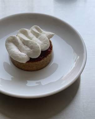 Beyaz tabakta çilekli bir tabağın dikey görüntüsü.