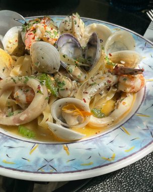 Beyaz tabakta deniz mahsullü makarna.