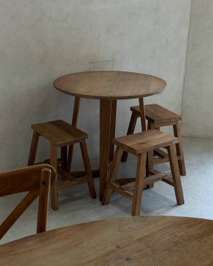 Odasında ahşap zemini olan beton bir duvarın arkasındaki boş ahşap masa..