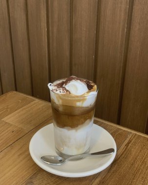 Ahşap bir masada bir fincan kapuçino..