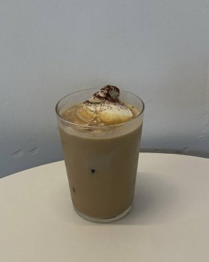 Beyaz arka planda cam bir fincanda buzlu kahve.