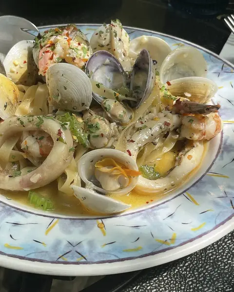 Beyaz tabakta deniz mahsullü makarna.