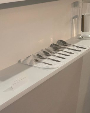 Beyaz mutfak lavabosu ve gri arka planda siyah bir ayna..