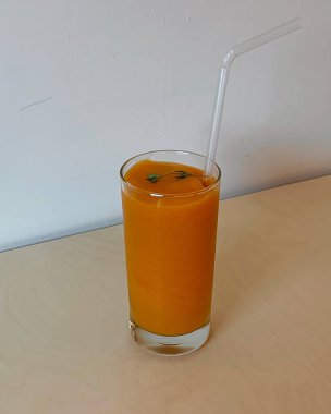 Beyaz arka planda bir bardak taze portakal suyu.