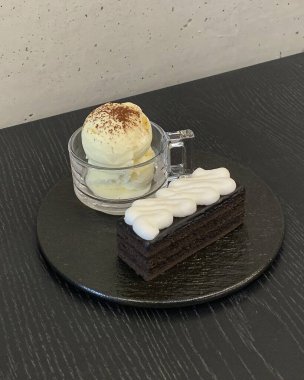 Beyaz bir tabakta beyaz bir kekin dikey görüntüsü.