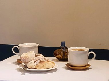 Kahve fincanı, masada kruvasan olan çay.