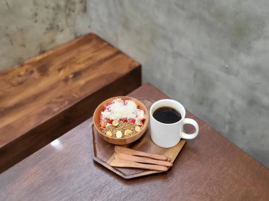 Kahve fincanı, üzerinde kek olan tahta masa.