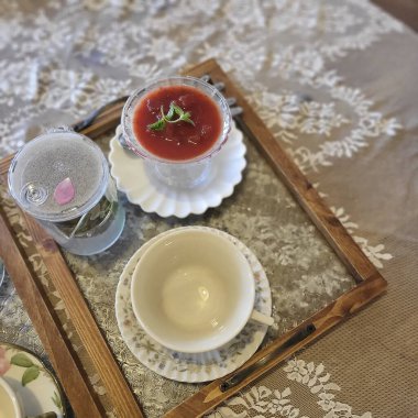 Kırmızı güllü bir fincan çay ve bir bardak su.