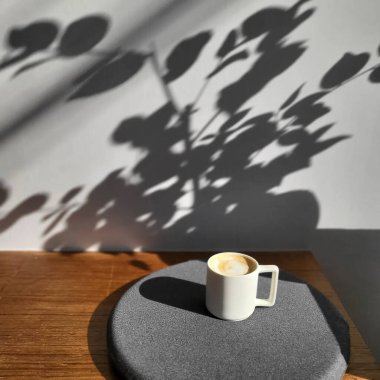 Kahve fincanı ve kahve çekirdekleri masanın üstünde.