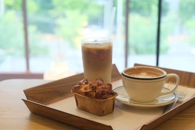 Kahve fincanı ve sıcak içecek kafedeki ahşap masada.