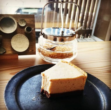 Tahta bir masada bir fincan kahve ve bir bardak süt.