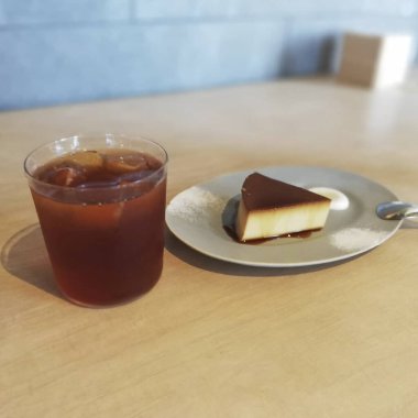 Bir parça kek ve beyaz ahşap bir masada bir fincan çay.