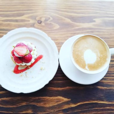 Bir tabak lezzetli kahvaltı, bir fincan çay ve bir kek.