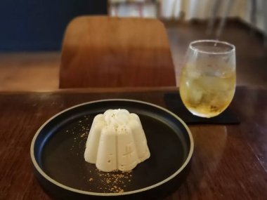 Tahta bir masanın üzerinde beyaz bir tabakla bir parça dondurmanın yakın plan çekimi.