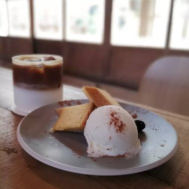 Dondurmalı bir fincan kahve ve ahşap masada bir fincan çay..