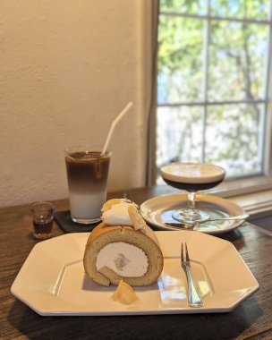 Bir fincan kahve ve ahşap bir masada kruvasan.