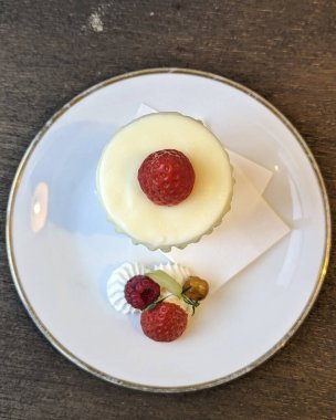 Bir parça taze peynirli kek ve ahududu.