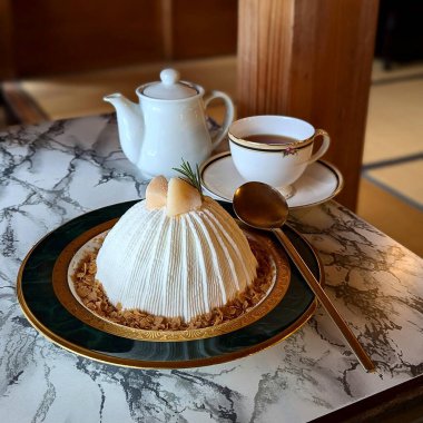 Kahve fincanı, çay ve ayçöreği ahşap masada.