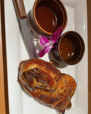 Siyah tahtada kaşık ve sosla ızgara ördek.