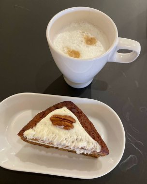 Bir fincan sıcak kahve, bir kaşık ve bir parça kek.