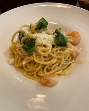 Bir kafede deniz ürünleri ve sebzeli lezzetli spagetti.