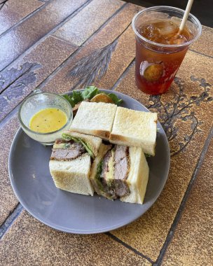 Bir tabak tavuklu ve patates kızartmalı sandviçin dikey yakın çekimi.