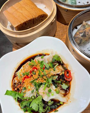 Ahşap masada Asya usulü domuz ve sebzeli Çin eriştesi.