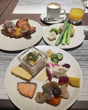 Kahvaltınız ve kahveniz bir fincan çayla birlikte masada.