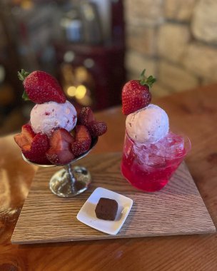 Çilekli lezzetli dondurma ve ahşap zemin üzerinde nane.