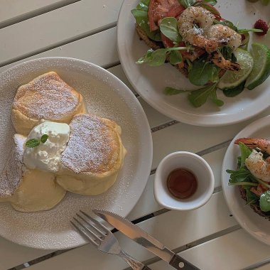 Somon ve kremalı pankekler ahşap masada.