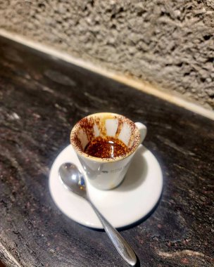 Kapuçinolu fincan ve siyah arka planda tarçınlı çikolata..
