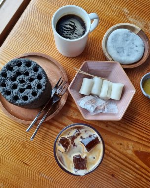 Tahta bir masada bir fincan çay ve bir fincan kahve.