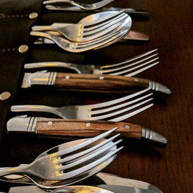 Mutfaktaki ahşap masadaki çatal bıçak takımı.