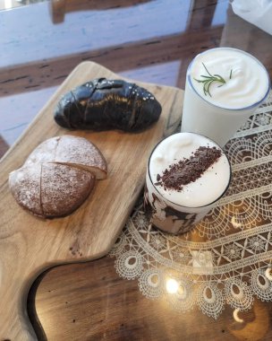 Bir fincan kahve ve ahşap masada bir pasta.