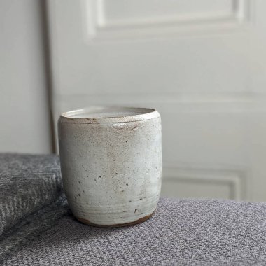 Ahşap bir masada boş bir seramik kabın dikey görüntüsü.